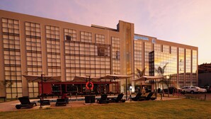 Un hotel moderno con un amplio ventanal de vidrio, zona de estar al aire libre y piscina.