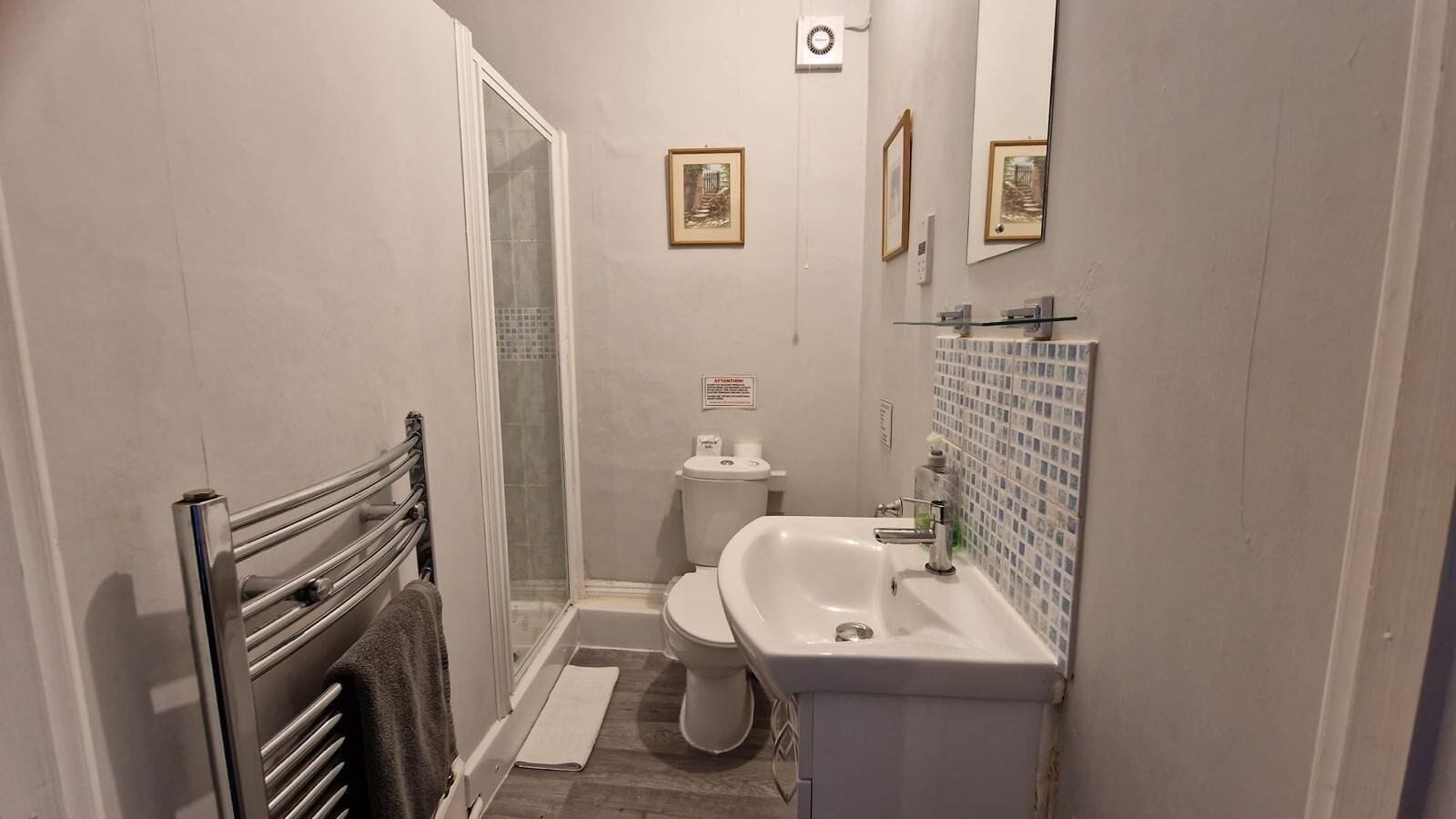 A small bathroom with a shower, toilet, and sink.