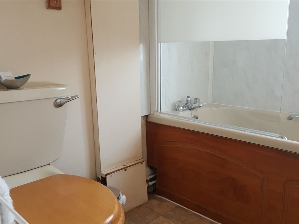 A bathroom with a toilet, sink, and bathtub.