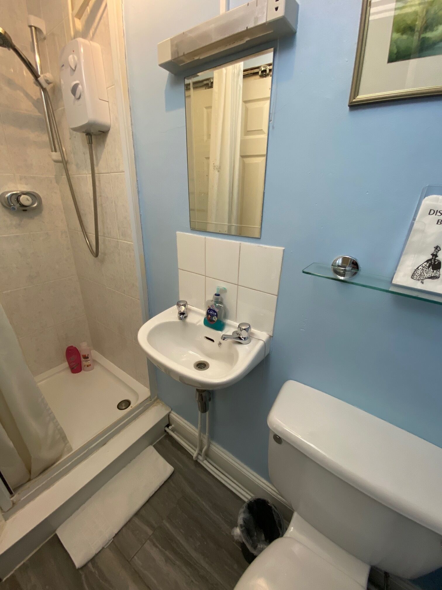 A bathroom with a shower, sink, and toilet.