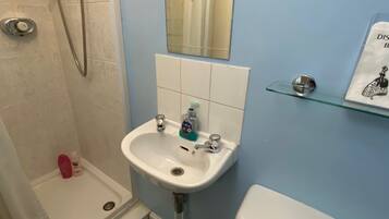 A bathroom with a shower, sink, and toilet.