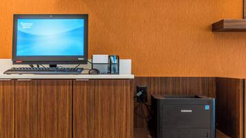 Una reception con un monitor computer, tastiera e una stampante Samsung.