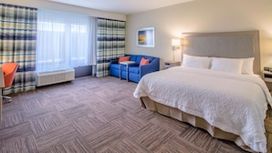 Une chambre d’hôtel avec un grand lit, un canapé bleu, une petite table et une chaise.