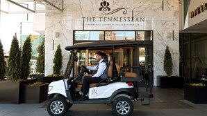 A golf cart parked in front of The Tennessean Personal Luxury Hotel & Residences.