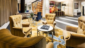 A lobby with plush seating, a chess table, and a reception desk.