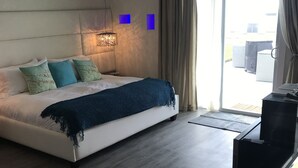 Une chambre d’hôtel avec un lit, un bureau, une télévision et une fenêtre avec des rideaux.