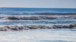 Une plage avec des vagues et un ciel dégagé.