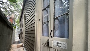 A narrow wooden pathway leading to a door with a sign reading "Blues Room." - Royal Barracks Guest House (New Orleans)