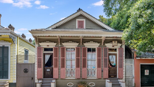 A two-story house with a gabled roof, a front porch, and a small front yard. - Royal Barracks Guest House (New Orleans)