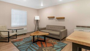 A modern living room with a sofa, a small table, a lamp, and a radiator.