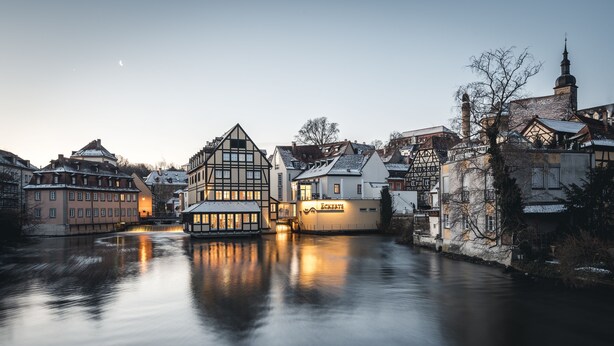 A historic town with traditional architecture along a calm river. - Hotel Nepomuk (Bamberg)