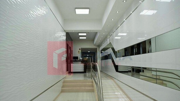 A modern interior with a staircase, glass railings, and a patterned wall. - Edificio California en Centro Histórico (Lima)