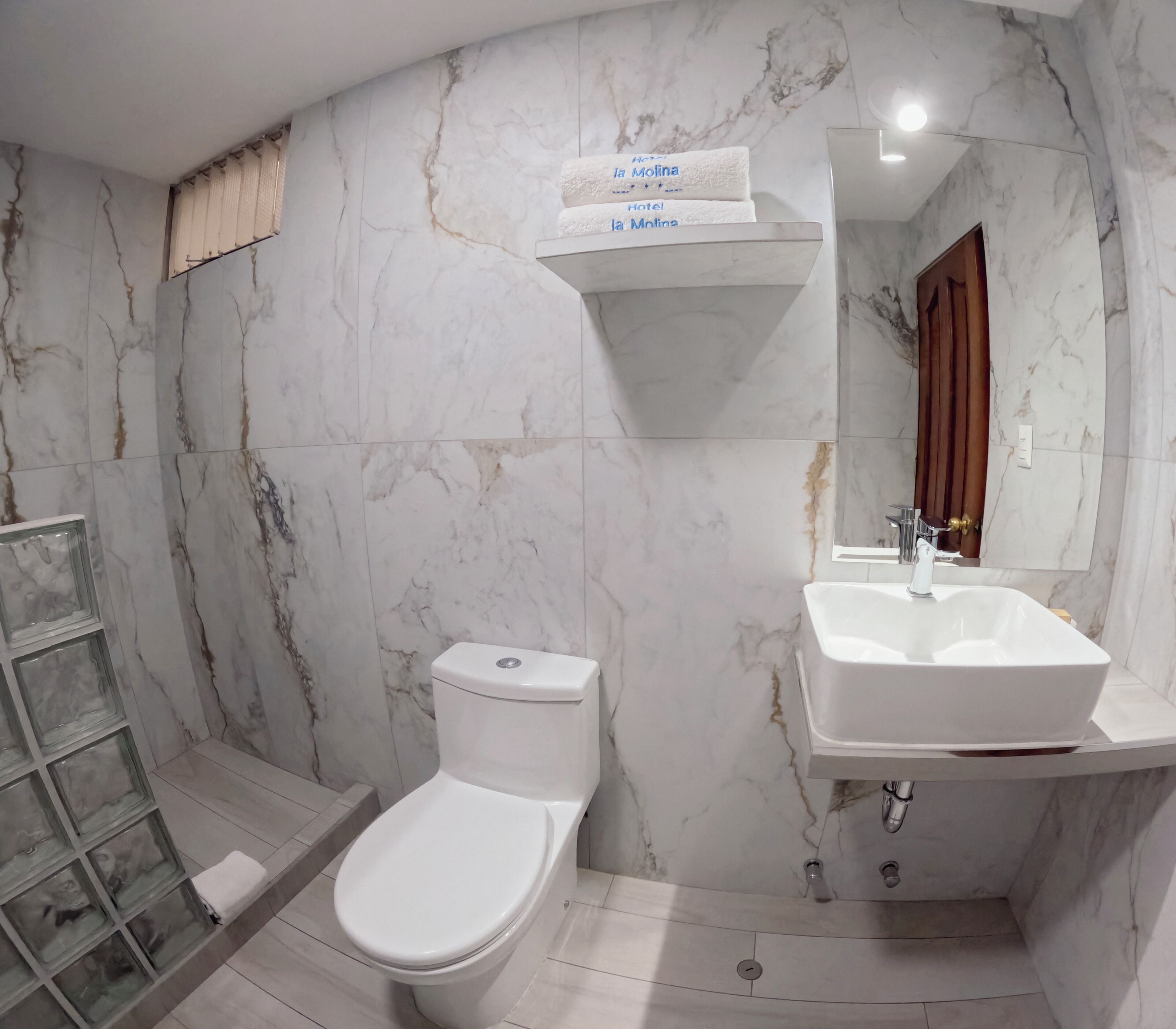 Un baño con inodoro, lavabo y espejo.
