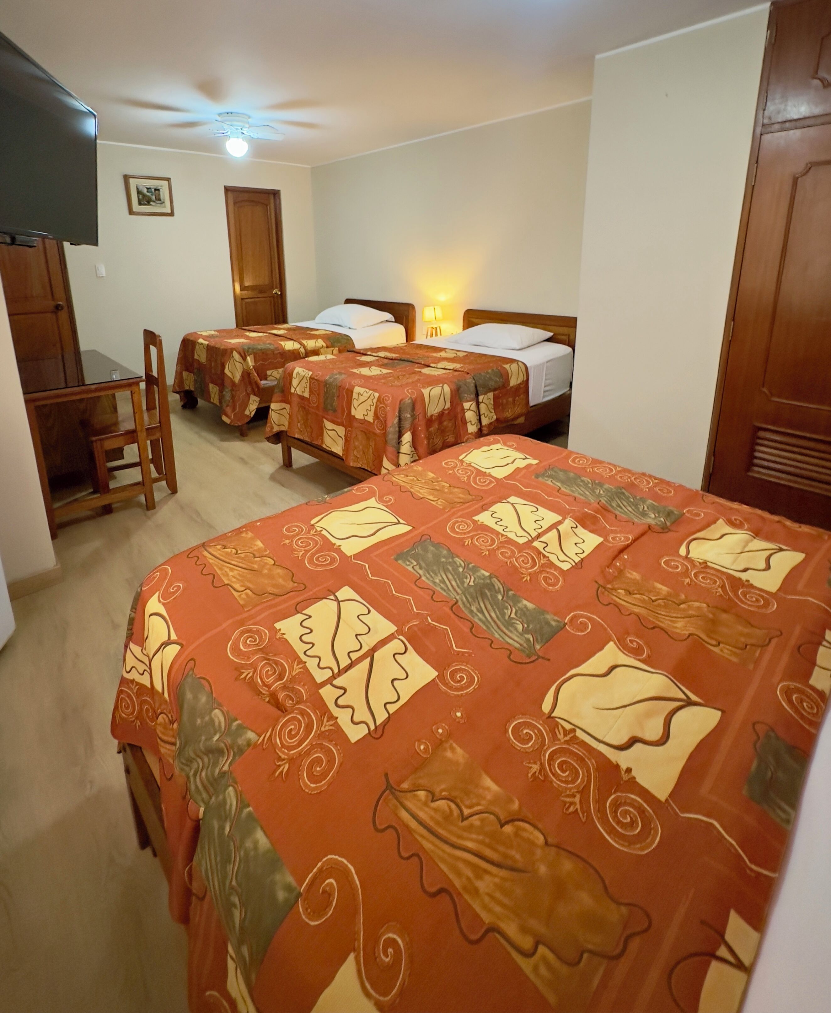Una habitación de hotel con dos camas individuales, un escritorio y una silla.