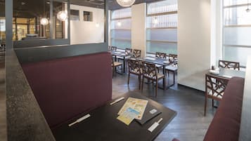 A restaurant with booths, tables, and hanging lights.