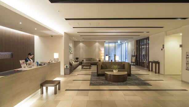 A modern lobby with a reception desk, seating area, and large windows. - Richmond Hotel Kumamoto Shinshigai (Kumamoto)