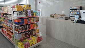 L'intérieur d'une épicerie, avec des étagères remplies de divers en-cas et de produits emballés.