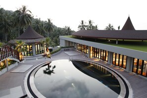 A resort with a swimming pool, a gazebo, and a building with a green roof.