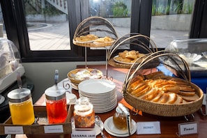 A breakfast buffet with various jams, honey, toast, and pastries. - Villa By The Tarna (Koh Tao)