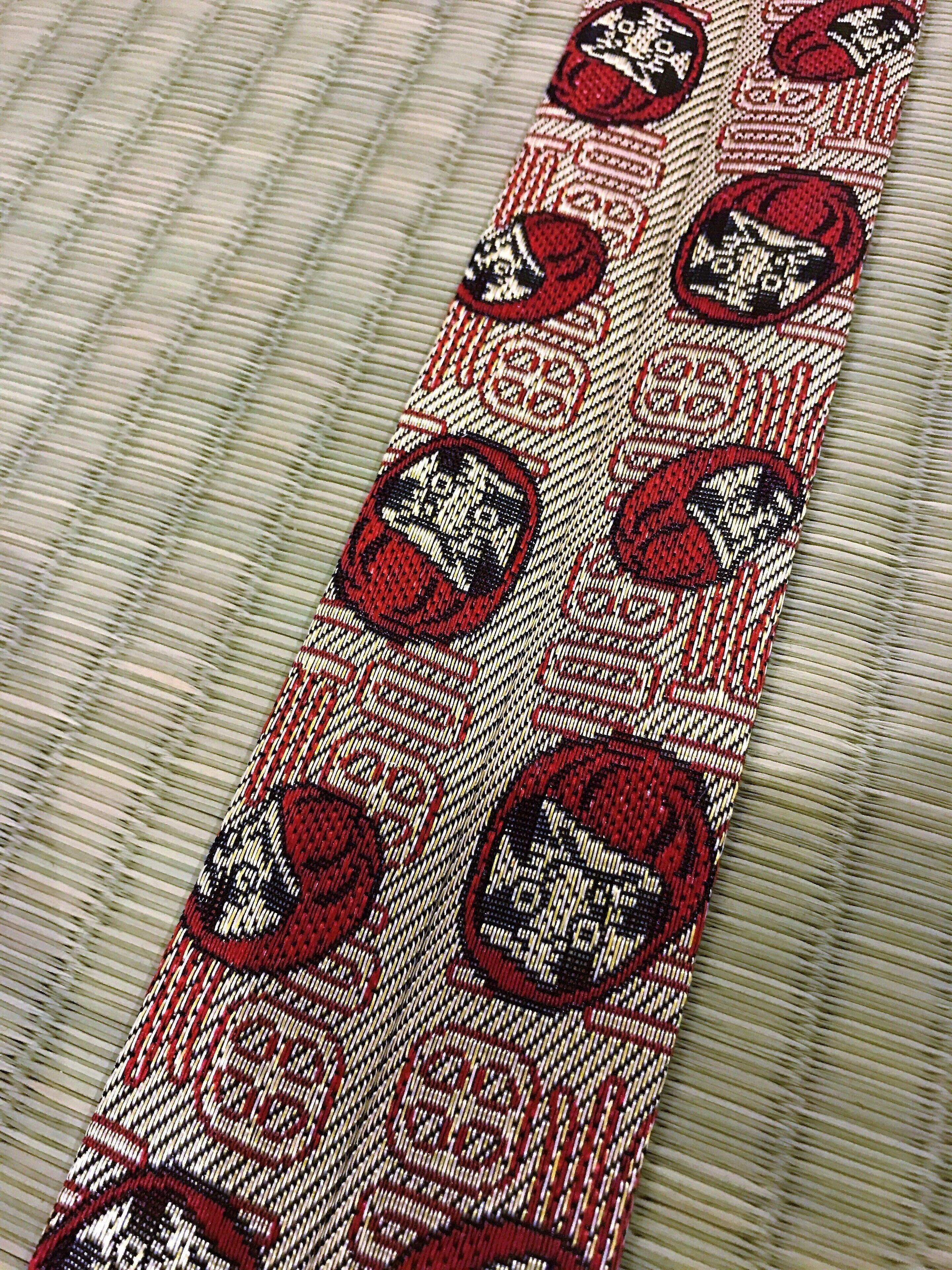 A patterned fabric with a series of red and black circular designs.