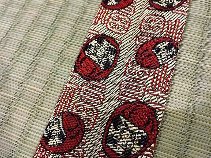 A patterned fabric with a series of red and black circular designs.