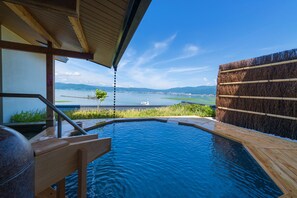 A hot tub with a wooden deck and a view of a lake and mountains. - Sosennoyado Suhaku (Suwa)