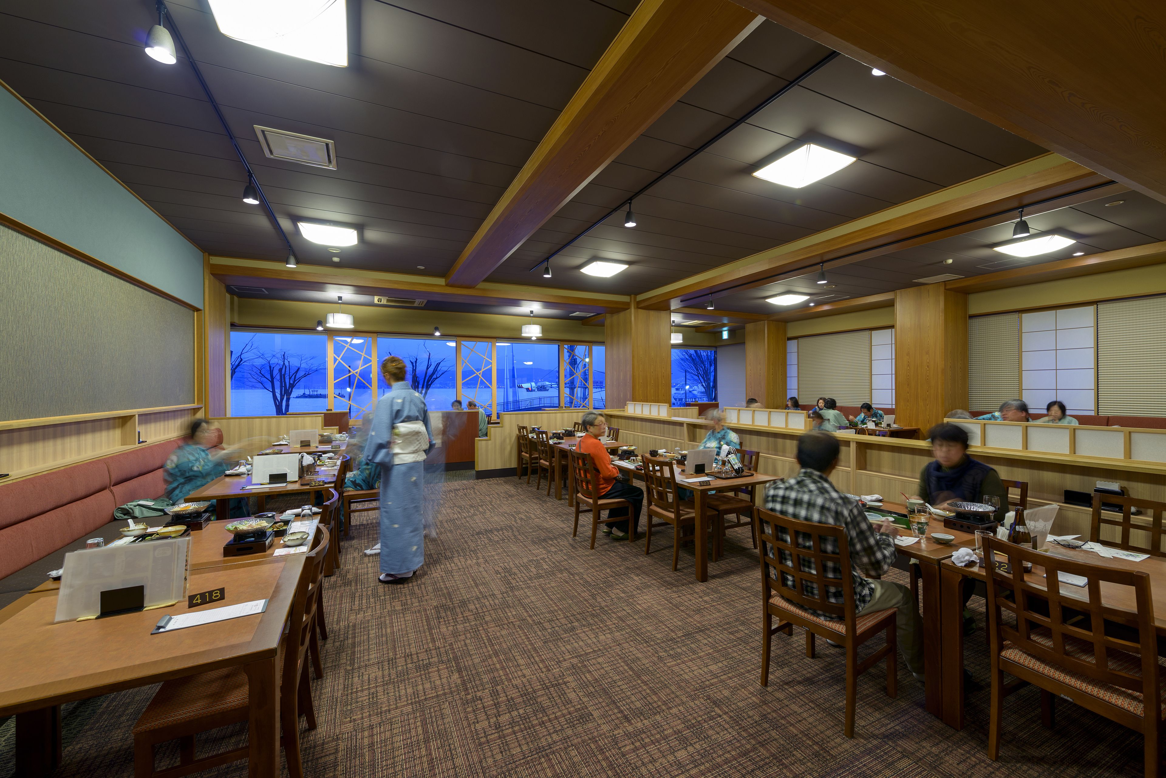 A dining area with booths and tables, a counter, and a view of the outside.