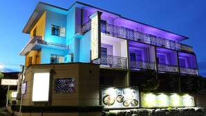 A multi-story building with balconies, illuminated signs, and a large illuminated menu display. - Hotel Olive Kyoto Yamashina - Adults Only (Kyoto)