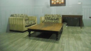 A living room with two patterned armchairs, a wooden coffee table, and a framed picture on the wall. - Bromo Sunrise Homestay (Probolinggo)