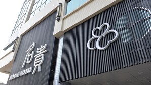 A hotel sign with a modern design and a logo. - Noble Hotel (Kaohsiung)