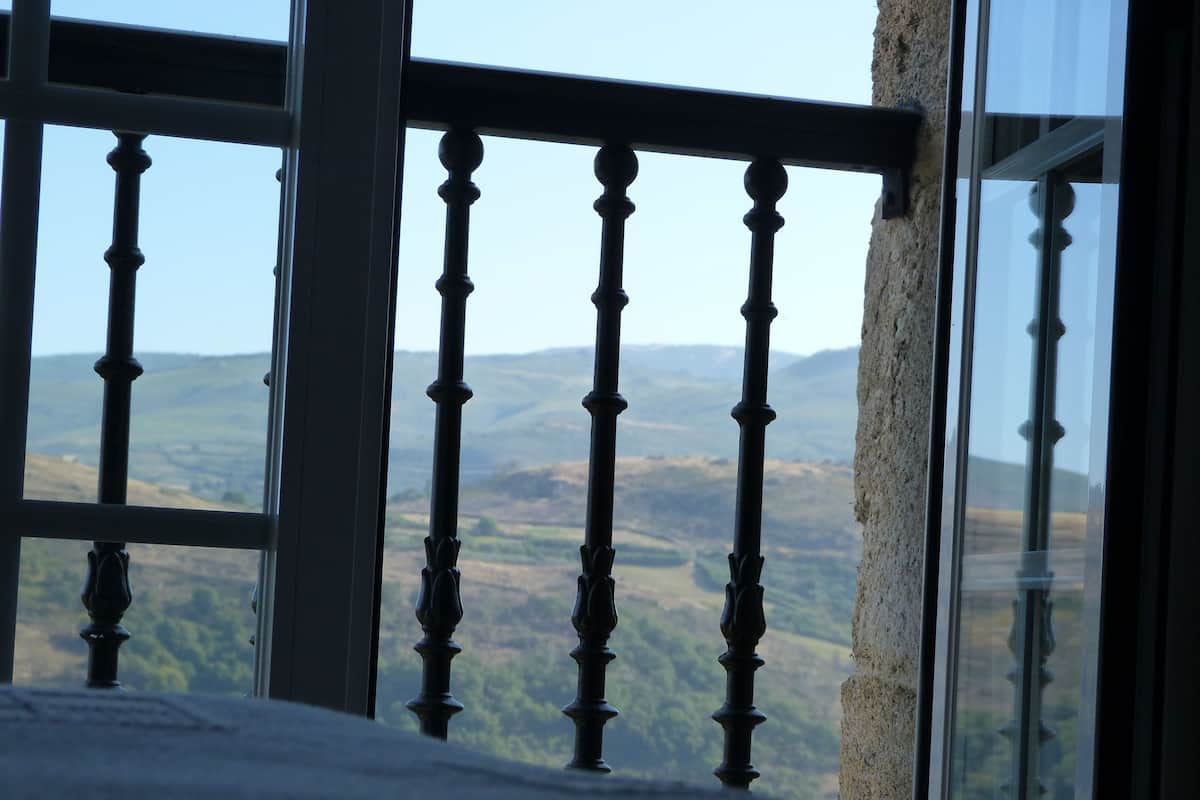 A balcony with a view of rolling hills.