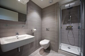 A modern bathroom with a glass-enclosed shower, a white sink, and a toilet. - Staycity Aparthotels, Lyon Rue Garibaldi (Lyon)