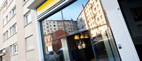 A Staycity apartment building facade with large windows and a yellow sign.