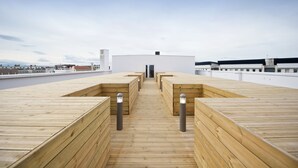 A wooden deck with benches and a central pathway leading to a building. - Staycity Aparthotels, Lyon Rue Garibaldi (Lyon)