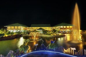 A hotel with a large outdoor pool, a fountain, and a sign indicating a 'Star Lounge'.