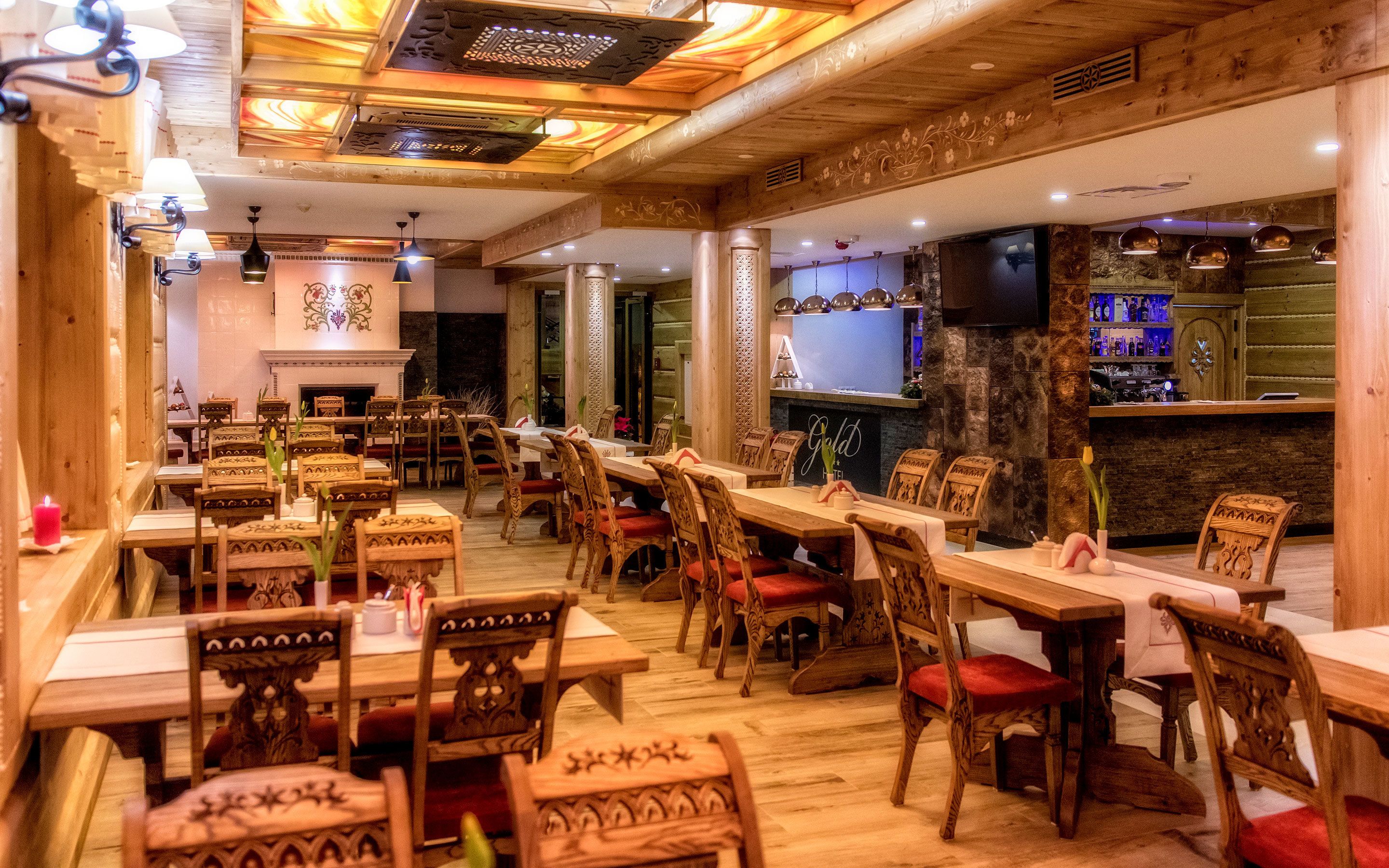 Un restaurant avec des tables et des chaises en bois, une cheminée et un coin bar.