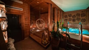 A wooden cabin interior with a hot tub, hanging chairs, and a small lantern. - Gold Hotel (Zakopane)