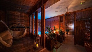 A wooden interior with a hanging chair, lantern, and potted plants. - Gold Hotel (Zakopane)