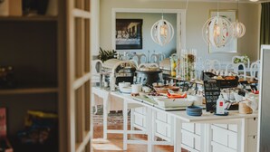 A kitchen area with white cabinetry, a coffee machine, and various kitchen utensils.