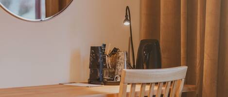 A wooden desk with a chair, a lamp, and a coffee maker.