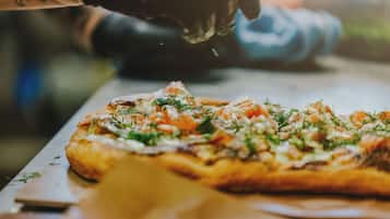 En pizza med olika ingredienser ovanpå, som står på ett bord.