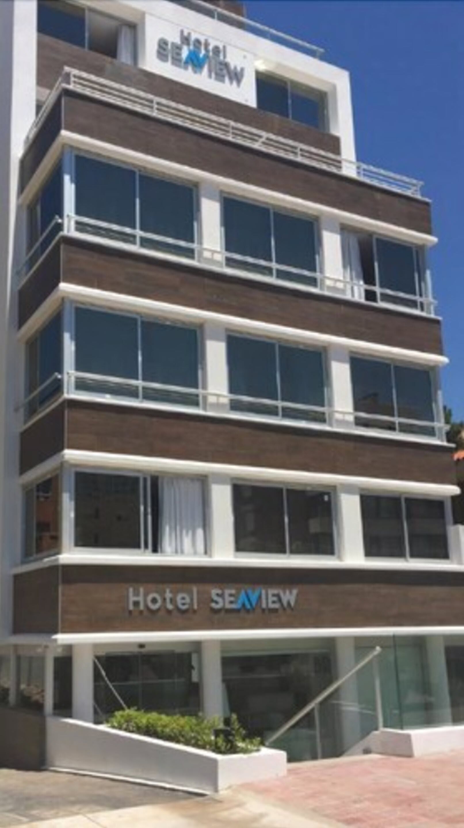 A multi-story hotel with a modern design, featuring large windows and a prominent sign reading "Hotel SEAMVIEW".