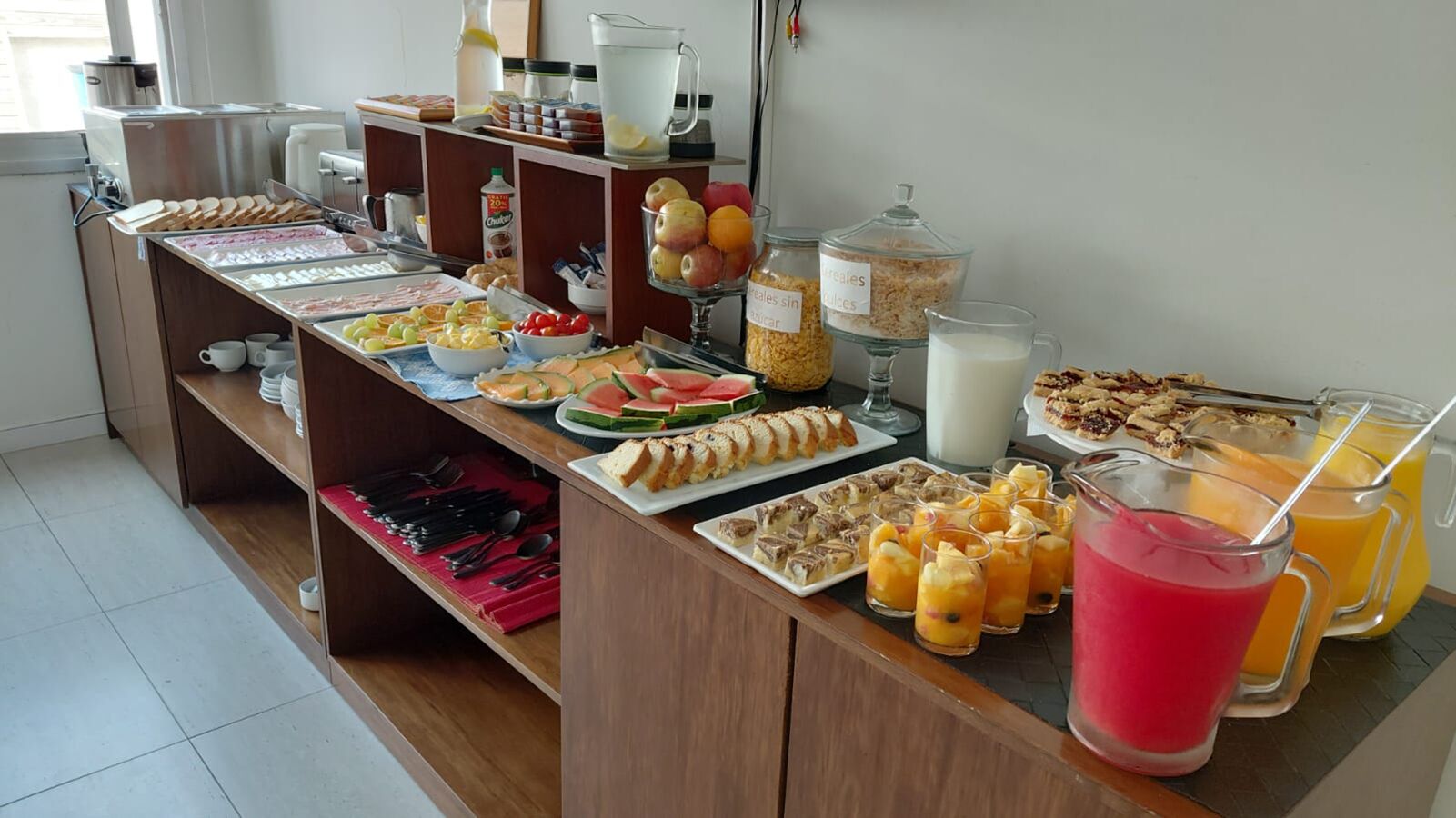 A buffet with various food items and beverages.