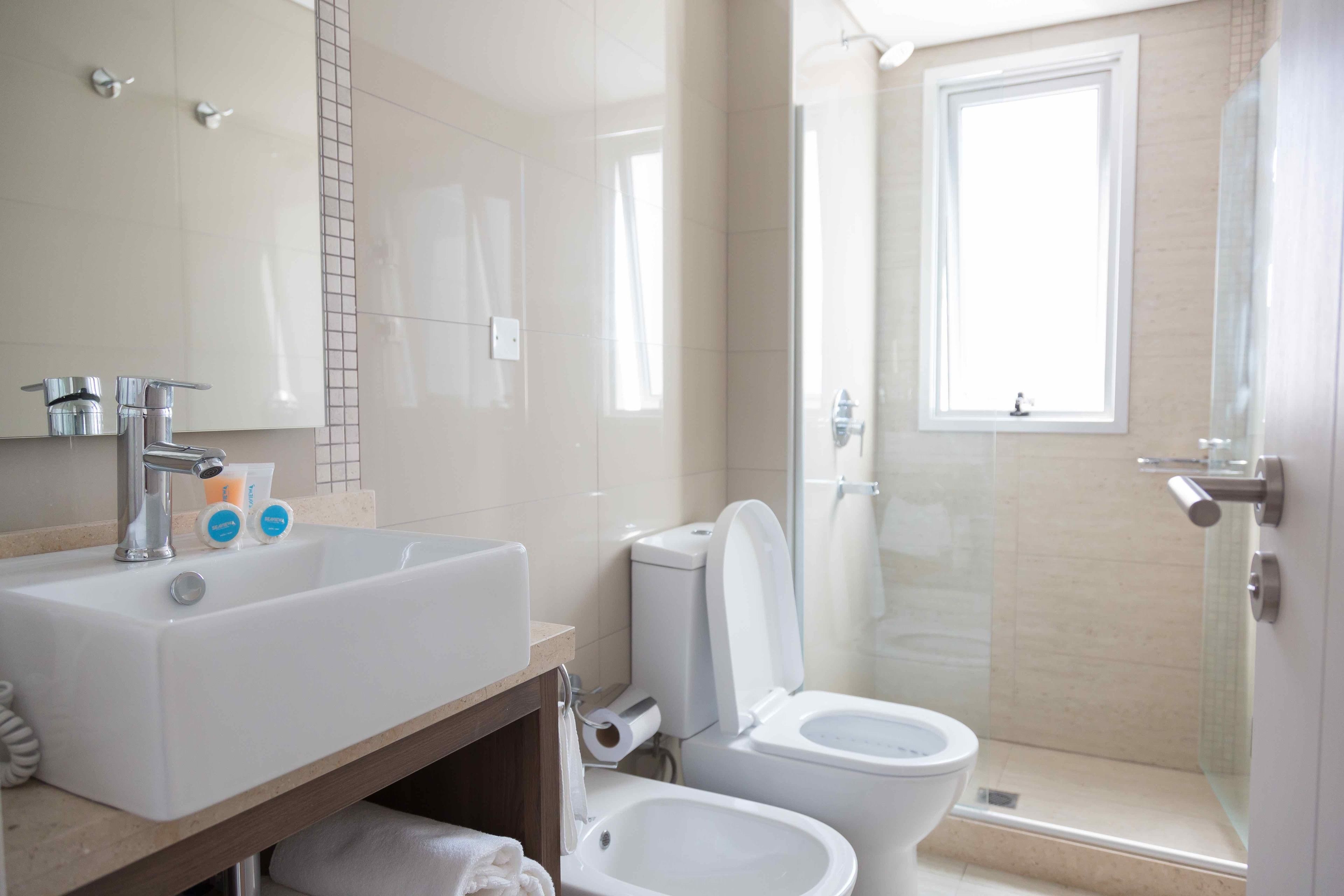 Une salle de bain moderne équipée d’un lavabo, de toilettes, d’un bidet et d’une douche.