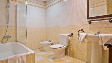 Un baño con bañera, bidé, inodoro y lavabo.