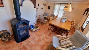 Ein gemütliches Wohnzimmer mit Kamin, einem Esstisch mit Stühlen und einer komfortablen Sitzecke.