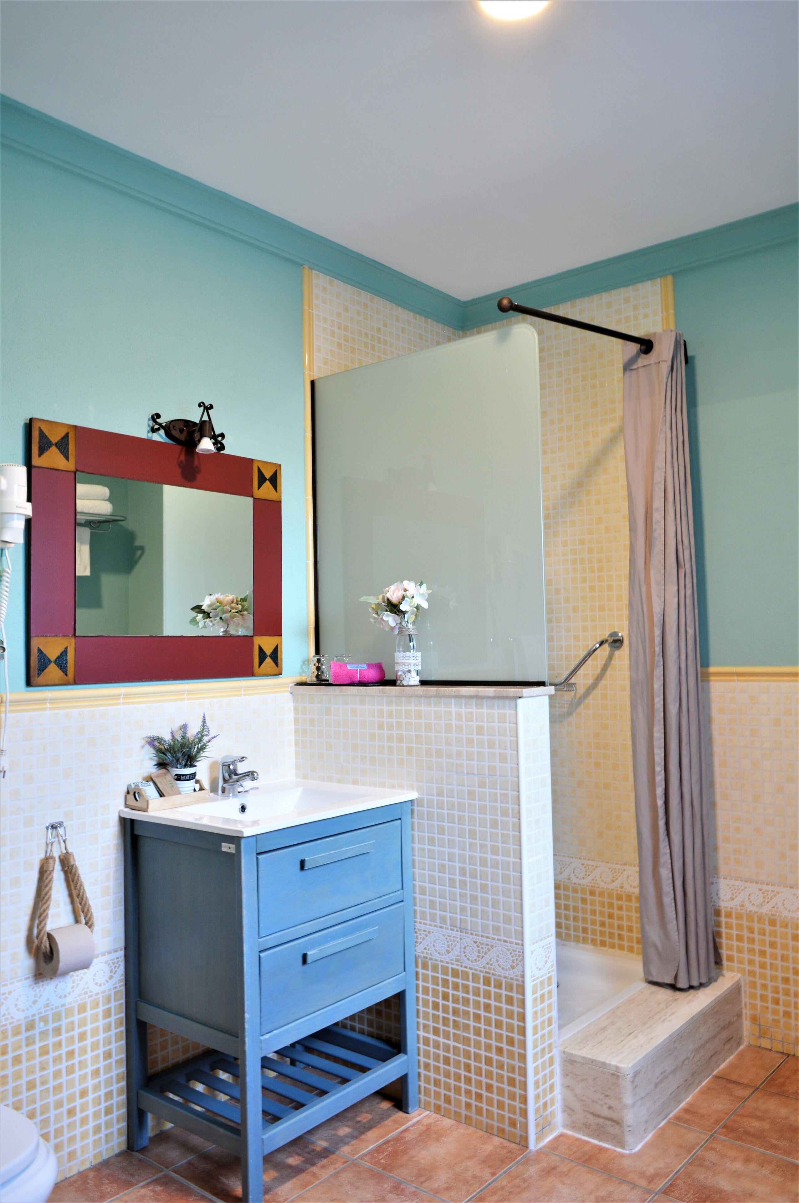 A bathroom with a sink, mirror, and shower.