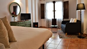 Ein Schlafzimmer mit Bett, Schminktisch, Fernseher, Schlafsofa und Lampe.