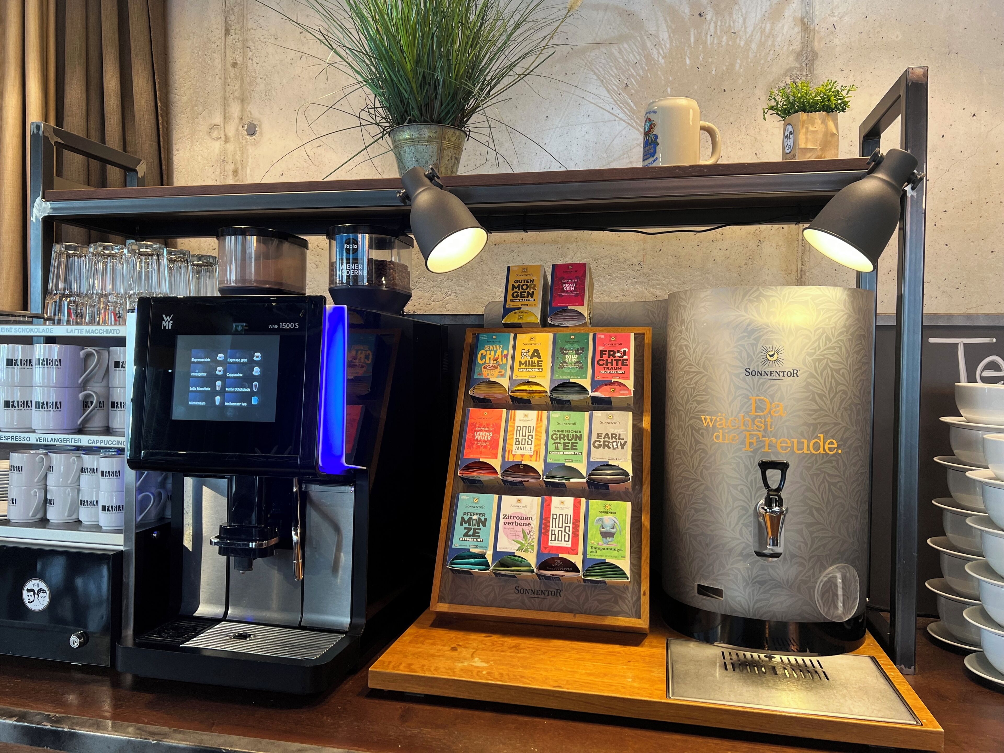 Una cafetera, una presentación de cápsulas de café y un dispensador de agua.