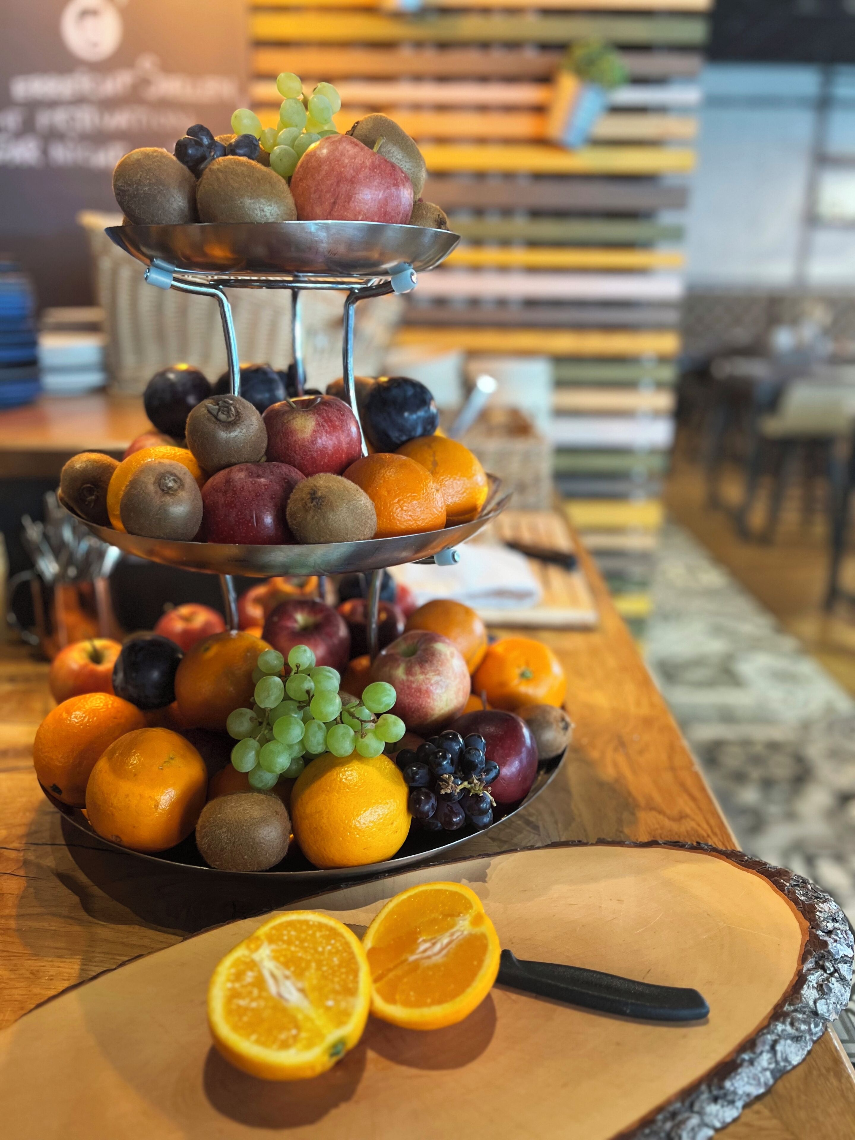 A fruit display with apples, oranges, grapes, and kiwis on a table.